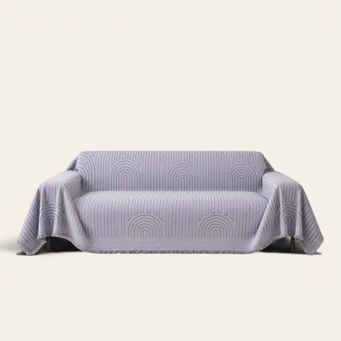 Misty Gray Arcane Ambiance sofa throw draped over a two-seat sofa, front view on ivory background, arched line pattern