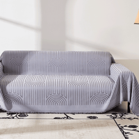 Misty Gray Arcane Ambiance throw over a sofa in sunlight, concentric arch motifs above a patterned rug