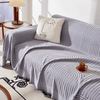 Misty Gray Arcane Ambiance throw styled on a sofa with a face cushion, amber mug and side lamp