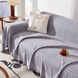 Misty Gray Arcane Ambiance throw styled on a sofa with a face cushion, amber mug and side lamp