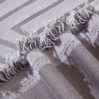 Close-up of Misty Gray Arcane Ambiance fringed edge with tassels and a woven arch motif