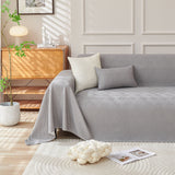 Graphite mist Artisan Cooling throw styled on a sofa with cushions and a wood cabinet in a bright room