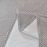 Detail of the graphite mist Artisan Cooling throw's folded corner revealing its quilted geometric backing