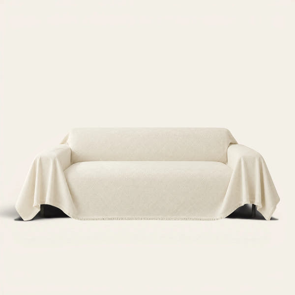 Artisan Cooling sofa throw in Ivory Cloud draped over a couch, front view on ivory background