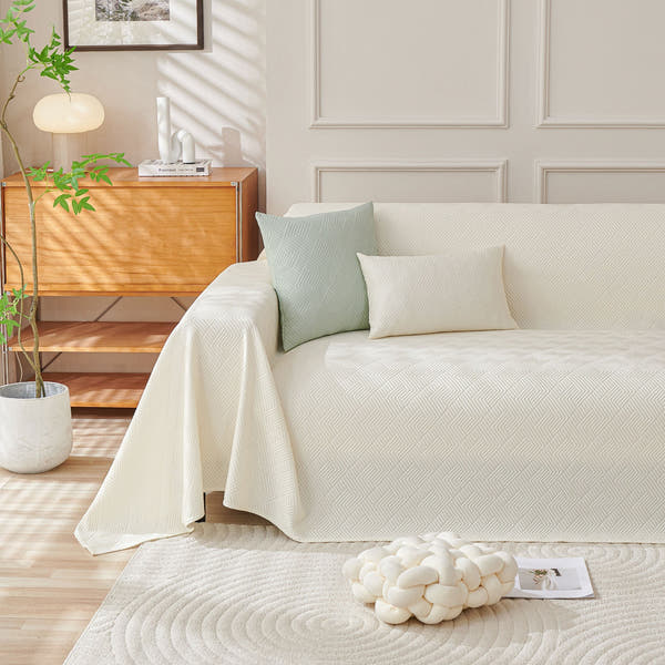 Ivory Cloud Artisan Cooling throw styled on a sofa with sage cushions in a bright room
