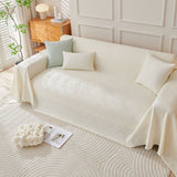 Artisan Cooling throw in Ivory Cloud over a sofa with cushions, lamp and side table, angle view