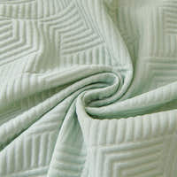 Macro of Mint Veil Artisan Cooling fabric swirled to show its embossed geometric maze quilting
