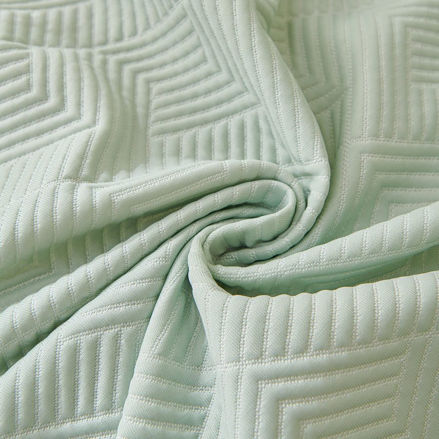 Macro of Mint Veil Artisan Cooling fabric swirled to show its embossed geometric maze quilting