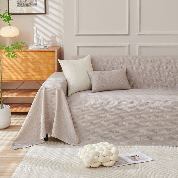 Shell Taupe Artisan Cooling throw styled on a sofa with cushions in a sunlit living room