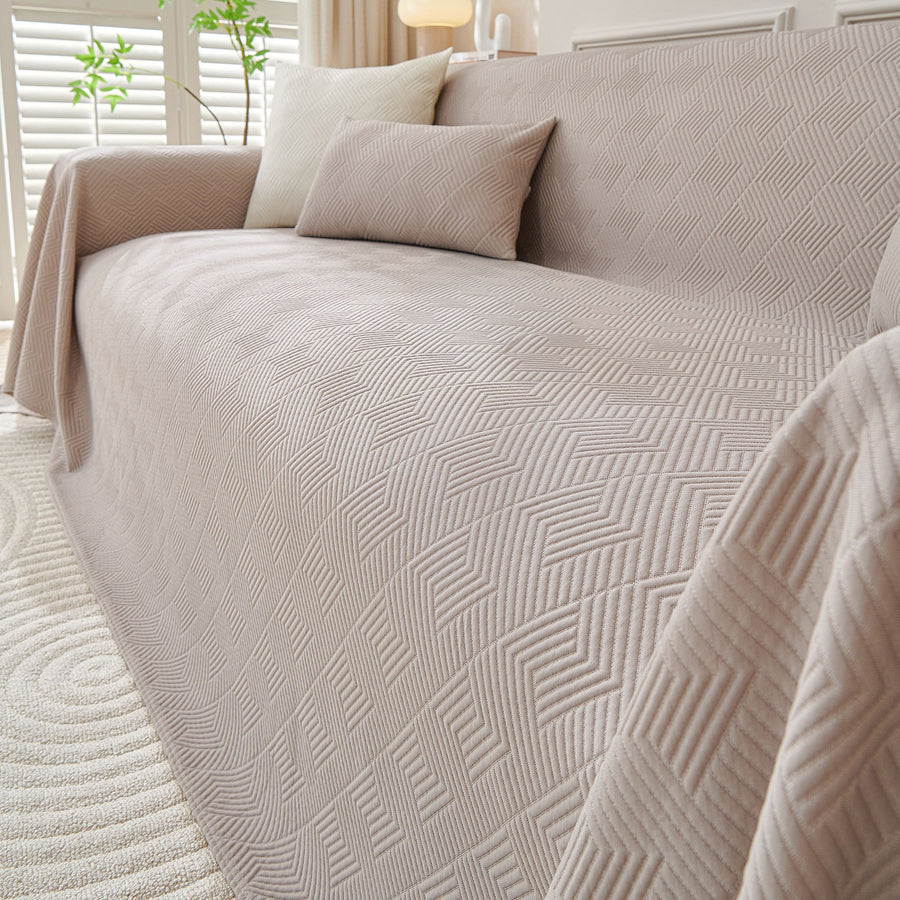 Angled close view of the Shell Taupe Artisan Cooling throw over a sofa corner, quilted diamond texture