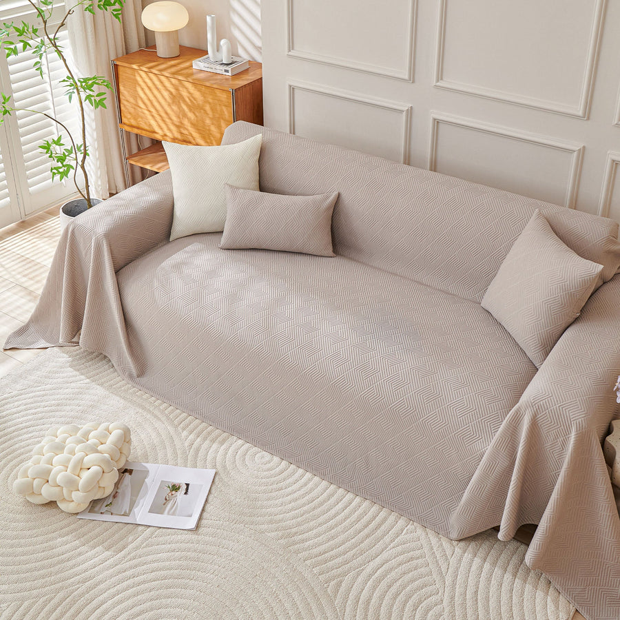 Shell Taupe Artisan Cooling throw covering a sofa with matching cushions in a bright paneled room