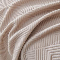 Close draped folds of the Shell Taupe Artisan Cooling throw with woven chevron texture