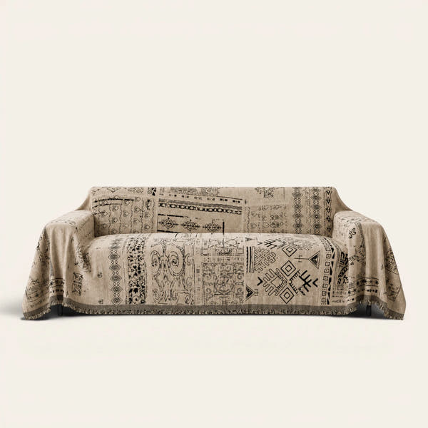 Sand Beige Artisan Glyph throw draped over a two-seat sofa on ivory background