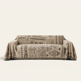 Sand Beige Artisan Glyph throw draped over a two-seat sofa on ivory background