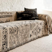 Artisan Glyph throw on a sofa corner styled with two black patterned cushions