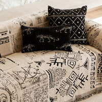 Close-up of the sofa seat showing black tribal glyphs and layered cushions