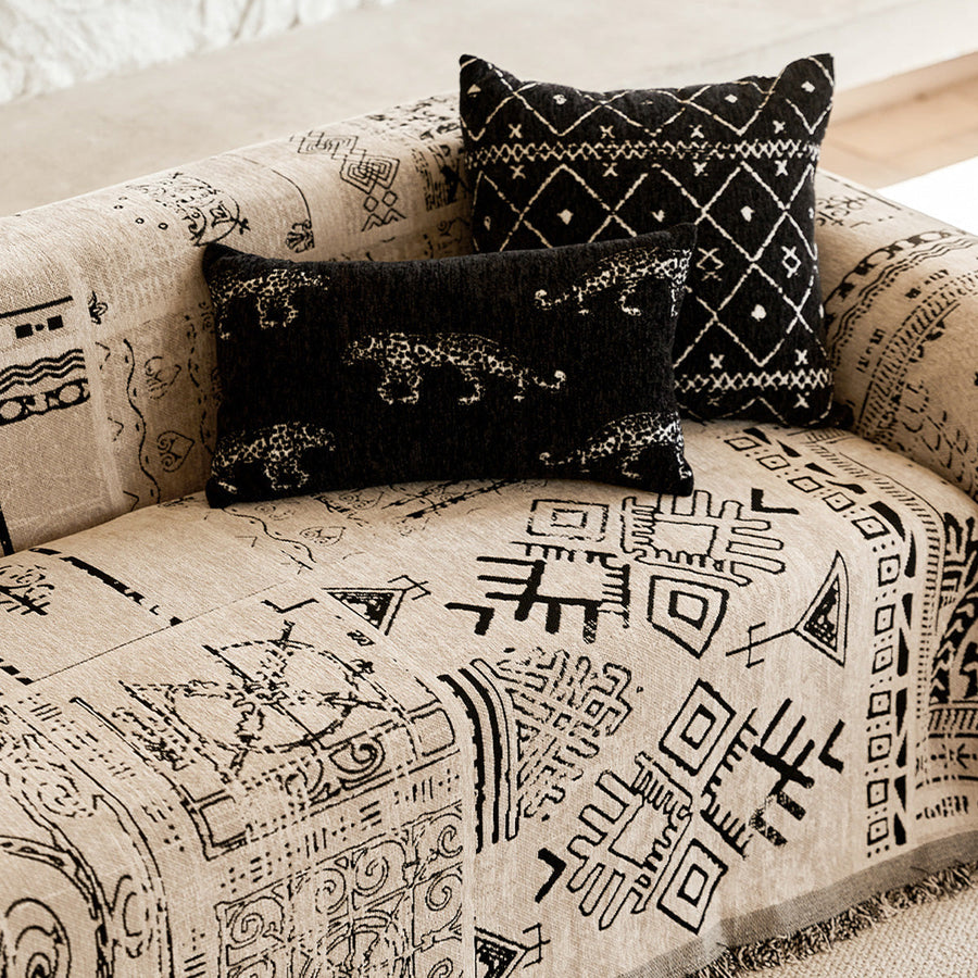 Close-up of the sofa seat showing black tribal glyphs and layered cushions
