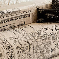 Detail of the sofa arm with the black glyph print and a leopard-motif cushion
