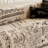 Detail of the sofa arm with the black glyph print and a leopard-motif cushion