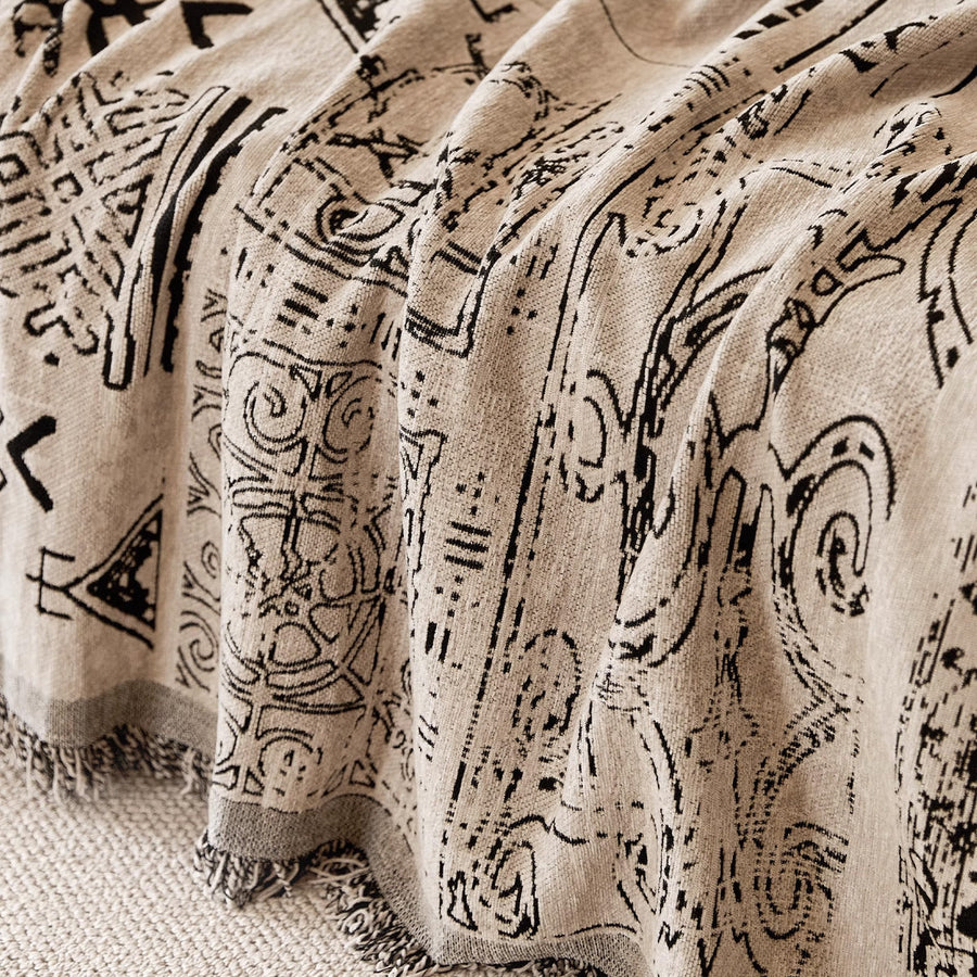 Macro of the sand beige fabric showing hand-drawn black artisan glyphs