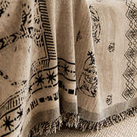 Close-up of the draped glyph throw with black symbols and fringed edge