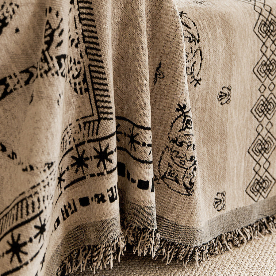 Close-up of the draped glyph throw with black symbols and fringed edge