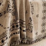 Close-up of the draped glyph throw with black symbols and fringed edge