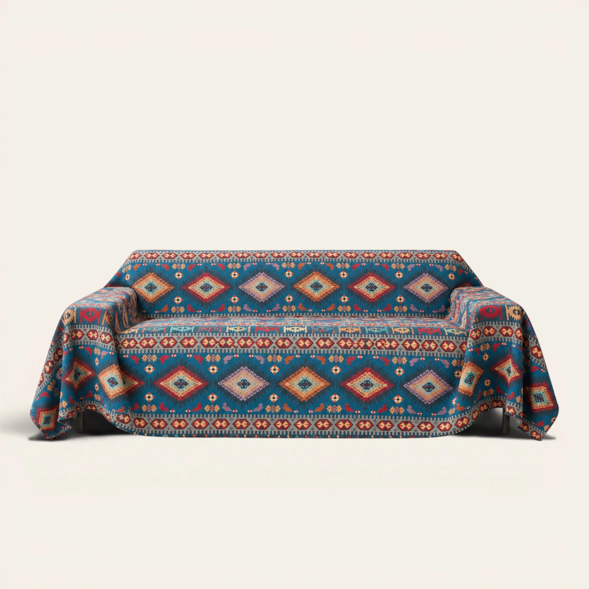 Azure Boho sofa throw in Indigo Oasis draped over a couch, front view on ivory background