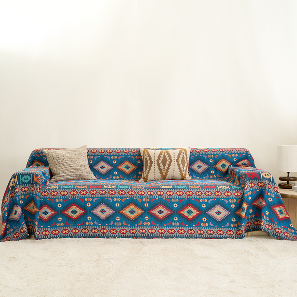 Indigo Oasis Azure Boho throw styled on a sofa with cushions and a lamp in a bright room