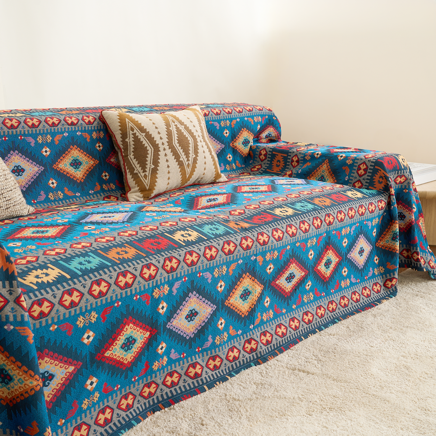 Azure Boho throw in Indigo Oasis over a sofa with patterned pillows, side angle close-up