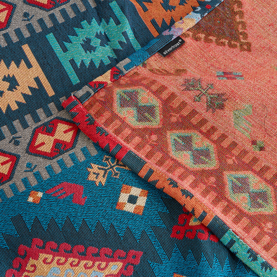 Close-up of the Indigo Oasis throw showing the teal and coral reversible woven sides