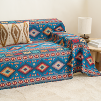 Indigo Oasis Azure Boho throw draped over a sofa arm and seat, three-quarter view with side table