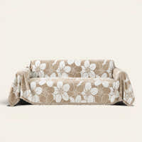 Mocha Latte Bloom Elegance sofa throw draped over a two-seat sofa, front view on ivory background, large white floral pattern