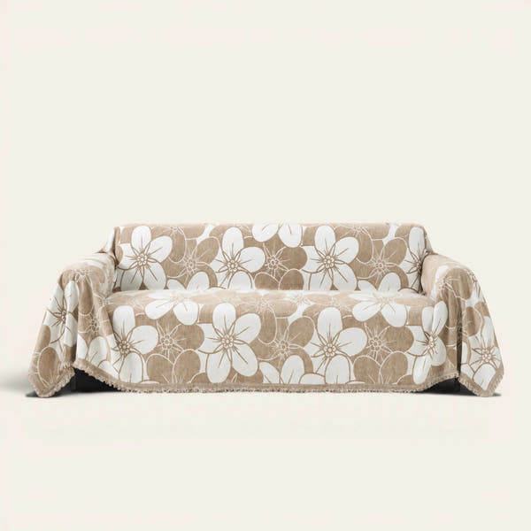 Mocha Latte Bloom Elegance sofa throw draped over a two-seat sofa, front view on ivory background, large white floral pattern