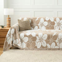 Mocha Latte Bloom Elegance throw styled on a sofa with a woven cushion and wooden lamp in a paneled room