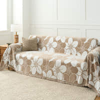 Mocha Latte Bloom Elegance throw over a sofa seat and arm with a floor lamp and patterned rug