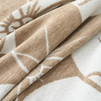 Close-up of Mocha Latte Bloom Elegance throw folded, white floral blooms on a soft chenille weave