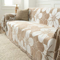 Angled view of Mocha Latte Bloom Elegance throw over a sofa with a cushion and lamp by a window