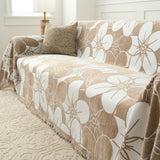 Angled view of Mocha Latte Bloom Elegance throw over a sofa with a cushion and lamp by a window