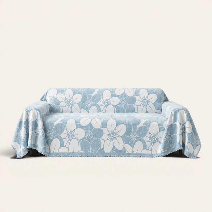 Bloom Elegance Ocean Bloom sofa throw draped over a three-seat sofa, front view on ivory