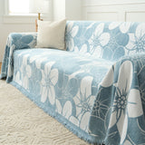 Bloom Elegance Ocean Bloom throw on a sofa, angled view with a cream cushion and rug