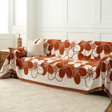 Rustic Blossom floral throw styled across a sofa with striped cushion and lamp