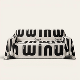 Graphic harmony Bold Typography sofa throw in black and white lettering, front view on an ivory backdrop