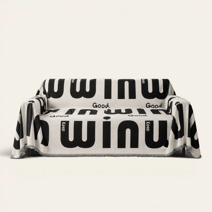 Graphic harmony Bold Typography sofa throw in black and white lettering, front view on an ivory backdrop