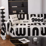 Graphic harmony Bold Typography throw styled on a sofa with slogan cushions and a sculptural floor lamp
