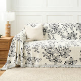 Botanic Sketch floral throw styled on a sofa against a paneled wall with a ribbed cushion and lamp