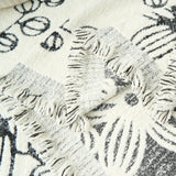Close-up of the sketched floral weave and frayed reversible seam of the Botanic Sketch throw