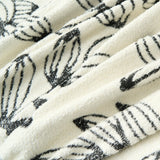 Macro of the sketched black floral fabric folds of the Botanic Bliss throw