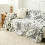 Botanic Sketch throw draped over a couch revealing the charcoal reversible side with cream flowers