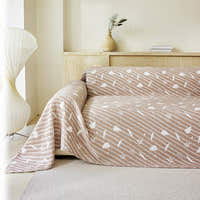 Linen Beige Botanical Quilted throw styled on a sofa with a vase and paper lamp in a bright room